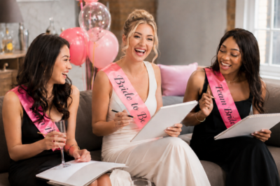 Bride-to-be and friends laughing and sketching at a hens party life drawing class